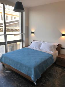 塞萨洛尼基Ladadika 5th Floor的一间卧室配有一张带蓝色毯子的大床