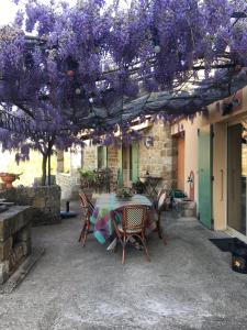 茹瓦厄斯奥可里克斯杜尚邦住宿加早餐旅馆的紫色树下带桌椅的庭院