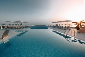 诺瓦利娅Hotel In Excelsis的一个带椅子和遮阳伞的大型游泳池