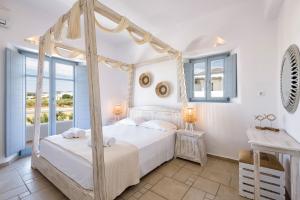 德里奥斯Villa Vanta的一间卧室设有四柱床和窗户。