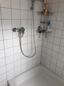杜塞尔多夫Einzel-Apartment Düsseldorf Oberkassel的白色瓷砖浴室设有淋浴和水槽