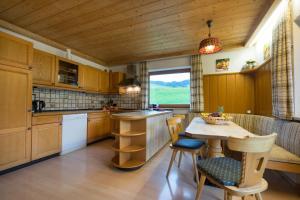 奥伯斯特多夫Ferienhof Alfred Albrecht的厨房配有木制橱柜和桌椅