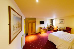 特伦特河畔伯顿三皇后酒店的酒店客房配有一张床、一张桌子和一把椅子。