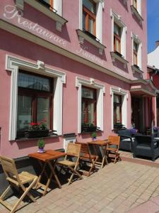 因德日赫城堡尤帕普斯克膳食公寓的粉红色的建筑,前面设有桌椅