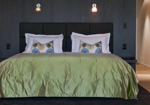 红山南Port Phillip Estate的一间卧室配有带四个枕头的绿色床