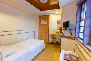 达沃市马诺酒店的配有一张床和一张书桌的酒店客房