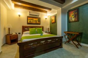 卡塔赫纳多雷迪亚酒店的一间卧室配有一张带绿色枕头的床