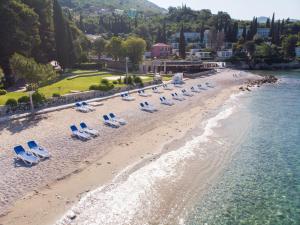 米利尼Maistra Select Mlini Hotel的海滩空中美景,配有椅子和水
