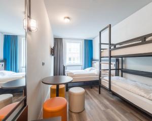 科隆科隆诺伊马克特A&O经济型连锁酒店的客房设有双层床和桌椅。