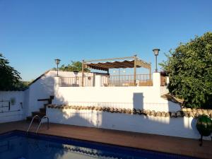 卡索拉Cortijo Los Abedules的白色的墙壁和带房子的游泳池