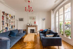 巴黎Veeve - Eiffel Elegance的客厅设有蓝色的沙发和壁炉