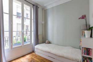 巴黎Veeve - Eiffel Elegance的一间卧室设有一张床和一个大窗户