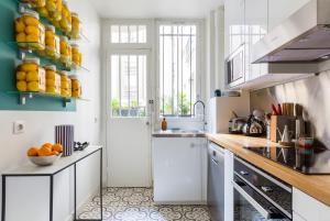 巴黎Veeve - Eiffel Elegance的厨房配有白色橱柜和柜台上的橙子