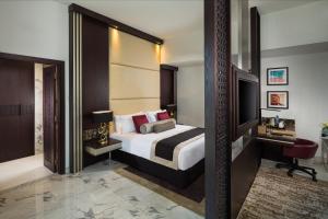 迪拜Millennium Place Dubai Marina的酒店客房,配有床和电视