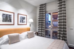 佛罗伦萨艺术画廊酒店 - 朗伽诺酒店集团的卧室设有一张白色大床和一扇窗户。