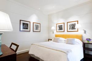 佛罗伦萨艺术画廊酒店 - 朗伽诺酒店集团的白色卧室配有一张大床和一张桌子