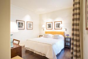 佛罗伦萨艺术画廊酒店 - 朗伽诺酒店集团的一间卧室配有带白色床单和枕头的床。