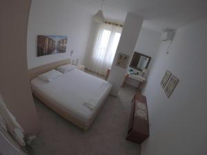 博尔什Villa Goxhi的卧室配有白色的床和电视。