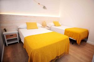 卡内·德·玛尔Apartamento frente al mar的配有黄色床单的客房内的两张床