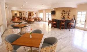 阿吉亚玛丽娜卡特里娜酒店的一间带桌椅的餐厅和一间酒吧