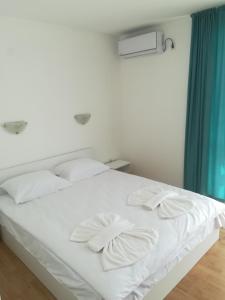 拉夫达Apartment Rutland的白色的床、白色枕头和蓝色窗帘