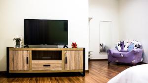 怡保TROPICAL LIVINGS MERU IPOH HOMESTAY by Grab A Stay的一间带电视和紫色椅子的客厅