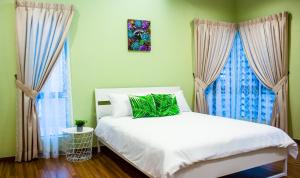 怡保TROPICAL LIVINGS MERU IPOH HOMESTAY by Grab A Stay的卧室配有白色的床和2扇窗户。