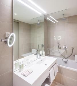 米利尼One Suite Hotel的一间带水槽和大镜子的浴室