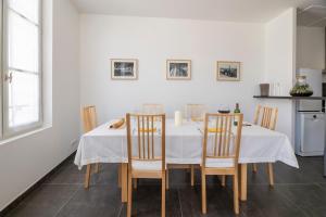 圣艾米隆Le 25, appartement moderne au cœur de Saint-Emilion的一间配备有白色桌椅的用餐室