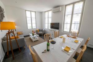 圣艾米隆Le 25, appartement moderne au cœur de Saint-Emilion的客厅配有带一瓶葡萄酒的白色桌子