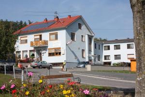MariasdorfGasthof Koller的街道上白色的建筑,有红色的屋顶