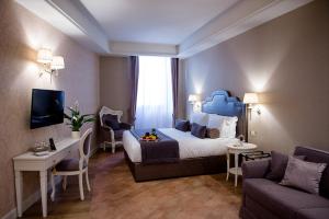 圣杰米尼San Gemini Palace的酒店客房设有一张大床和一张沙发。