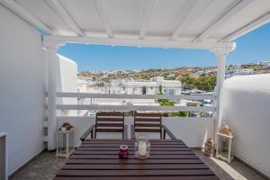 米克诺斯城Beautiful Apartment With Amazing View, In Mykonos Old Town的阳台的门廊配有2把椅子和1张桌子