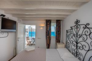 米克诺斯城Beautiful Apartment With Amazing View, In Mykonos Old Town的一间卧室配有一张床,墙上配有电视