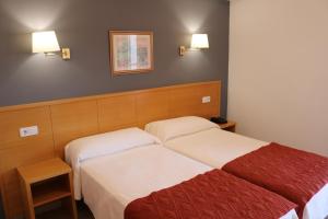 圣胡安·德·阿利坎特桑塔法兹酒店的酒店客房设有两张床和两盏灯。