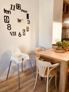 格丁尼亚Apartament Batorego 713的餐桌、椅子和墙上的时钟