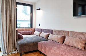 克拉科夫Rajska Blue Luxury Apartment的客厅里设有一张棕色沙发,配有窗户