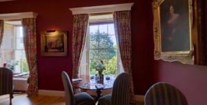 新罗斯Kilmokea Country Manor & Gardens的一间带桌子和窗户的用餐室