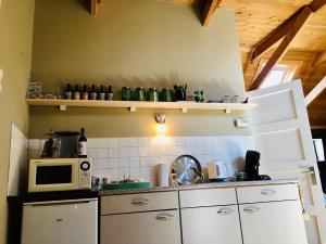 GarmingeOnder de Appelboom的厨房配有白色橱柜和微波炉