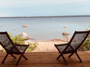 卡斯姆Small Vinter Summer House的两把椅子坐在甲板上,眺望水面