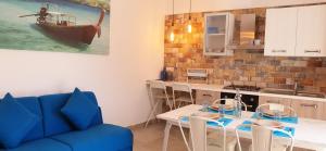 托雷拉皮罗La Baia Apartments的客厅配有桌子和蓝色沙发