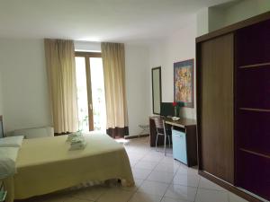 贝特纳斯科Hotel & Residence La Sibilla Cusiana的酒店客房,配有床和电视