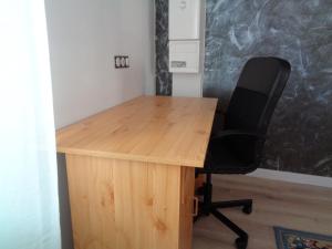 圣艾蒂安Appartement indépendant LE PANASSA, Centre ville, Garage privé的一张木桌,在房间内配有一张黑椅子