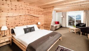 塞尔瓦迪加尔代纳山谷大陆酒店的一间卧室设有一张带木墙的大床