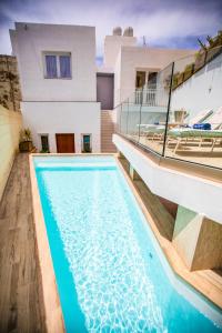 SiġġiewiPjazza Suites Boutique Hotel by CX Collection的房屋前有游泳池的房子