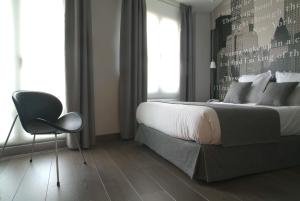 桑坦德乐珀蒂精品酒店的卧室配有床、椅子和窗户。
