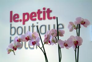 桑坦德乐珀蒂精品酒店的一组粉红色的花在标志前