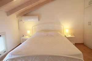 梅加尼西岛Xaradiotis House - A modern home away from home的配有两张桌子的房间的一张白色床