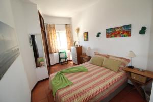 波尔蒂芒ApartamentoSolPraia - BeloHorizonte的一间卧室配有一张带绿色棉被的床