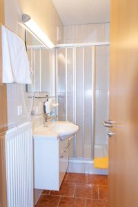 滨湖费尔德Strandhotel Burgstaller的一间带水槽和淋浴的浴室
